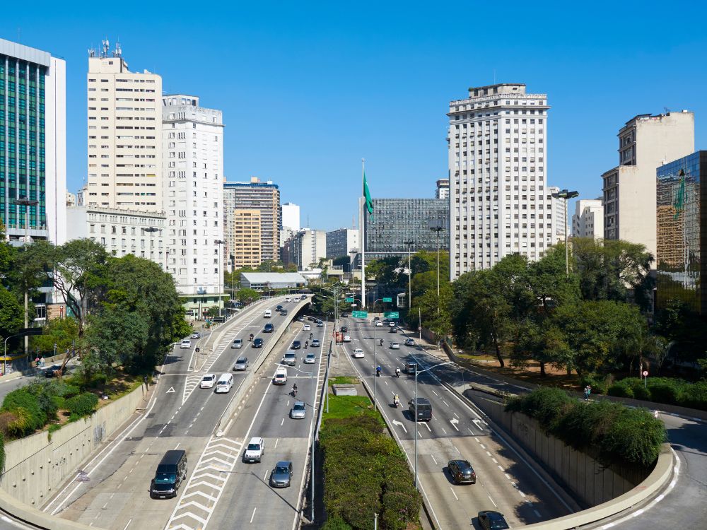 Vista urbana de São Paulo com prédios altos e avenida movimentada, representando rotina de quem trabalha na capital paulista.