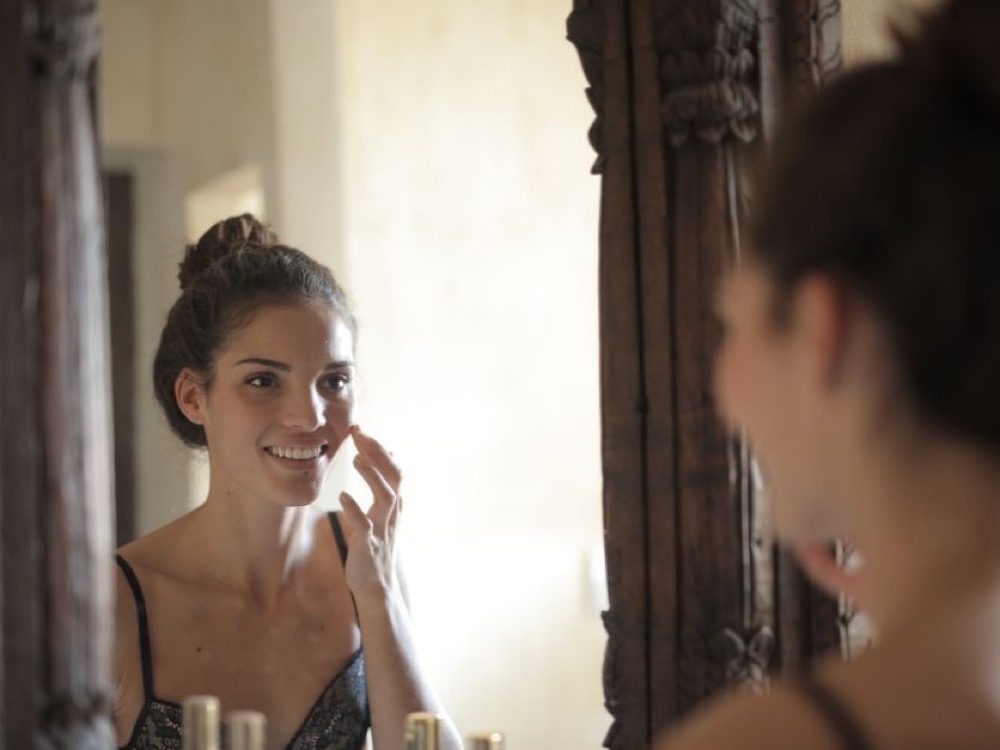 Mulher sorrindo, olhando no espelho